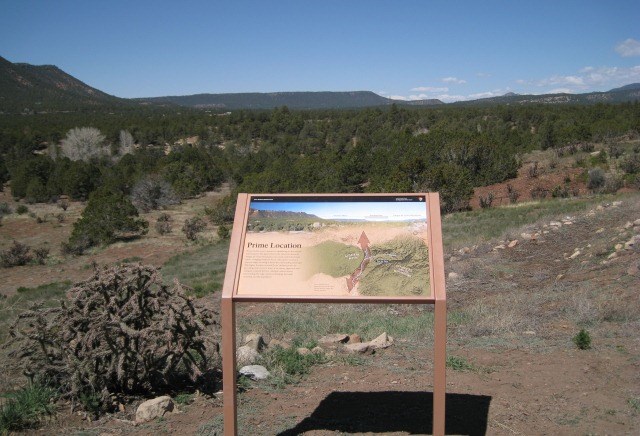brown sign with green mountain in background