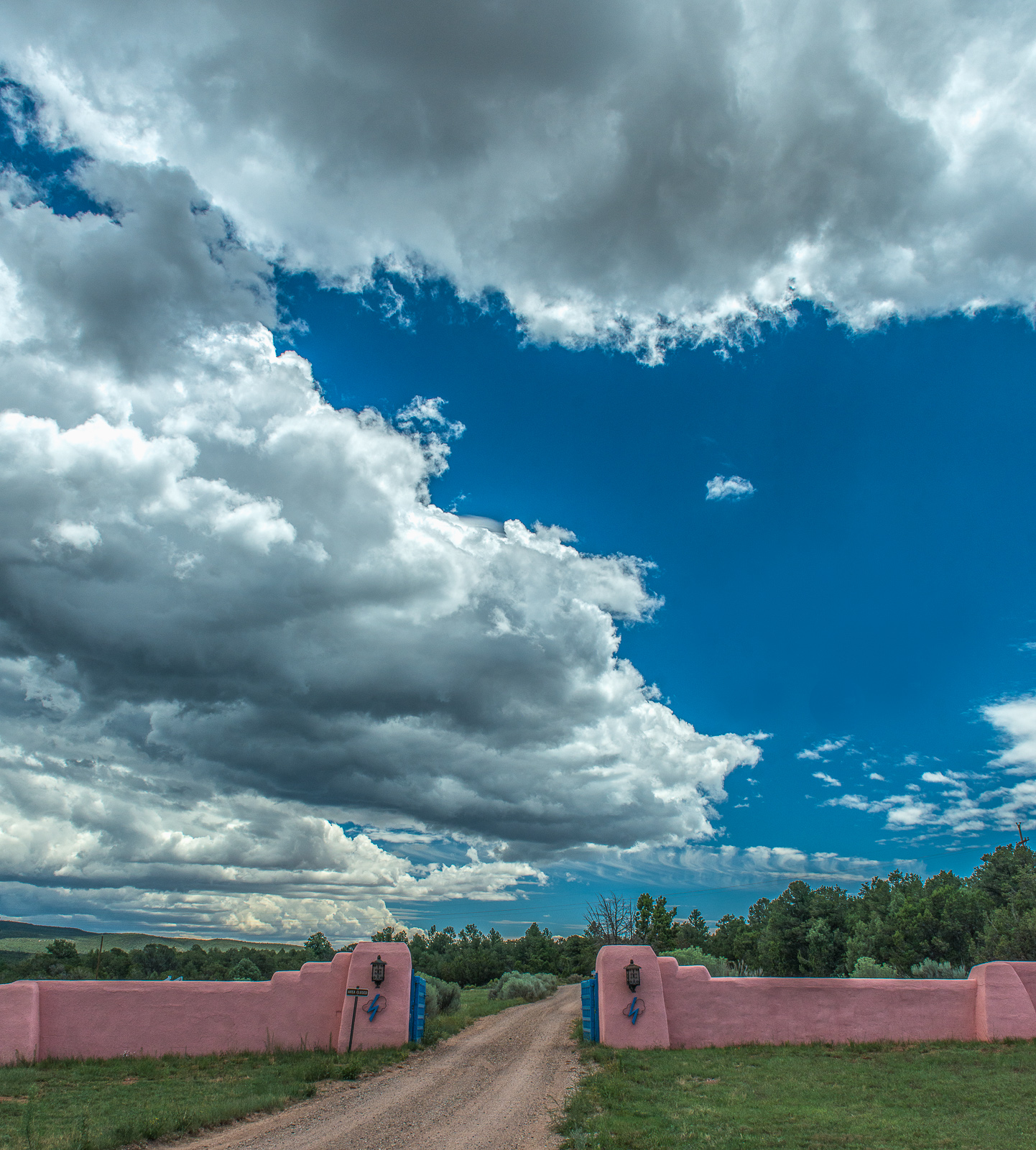 Forked Lightning Ranch entrance with blue sky. Pink and blue entrance gates with blue sky and clouds in the sky.