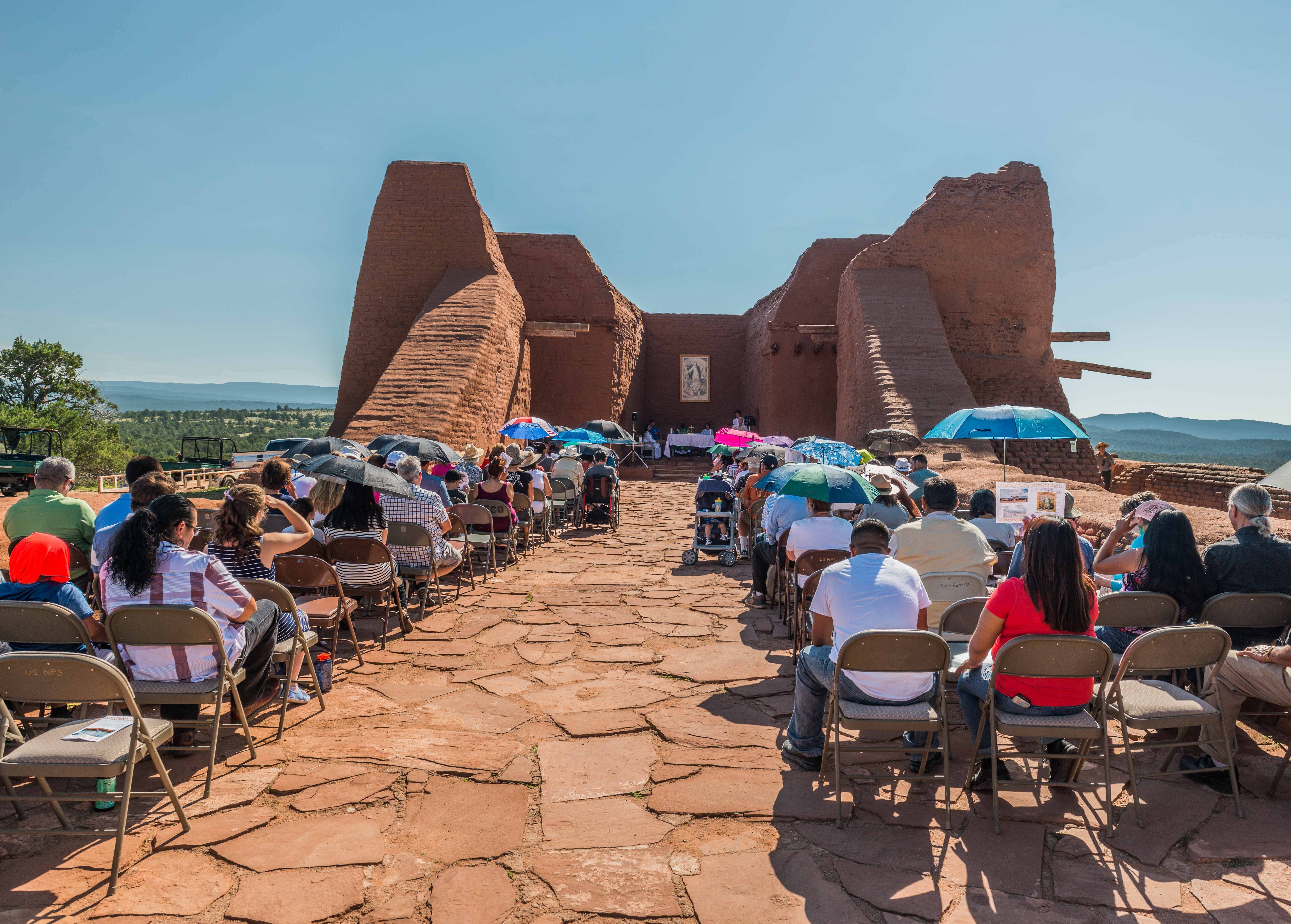 People sitting in rows in an ancient building.
