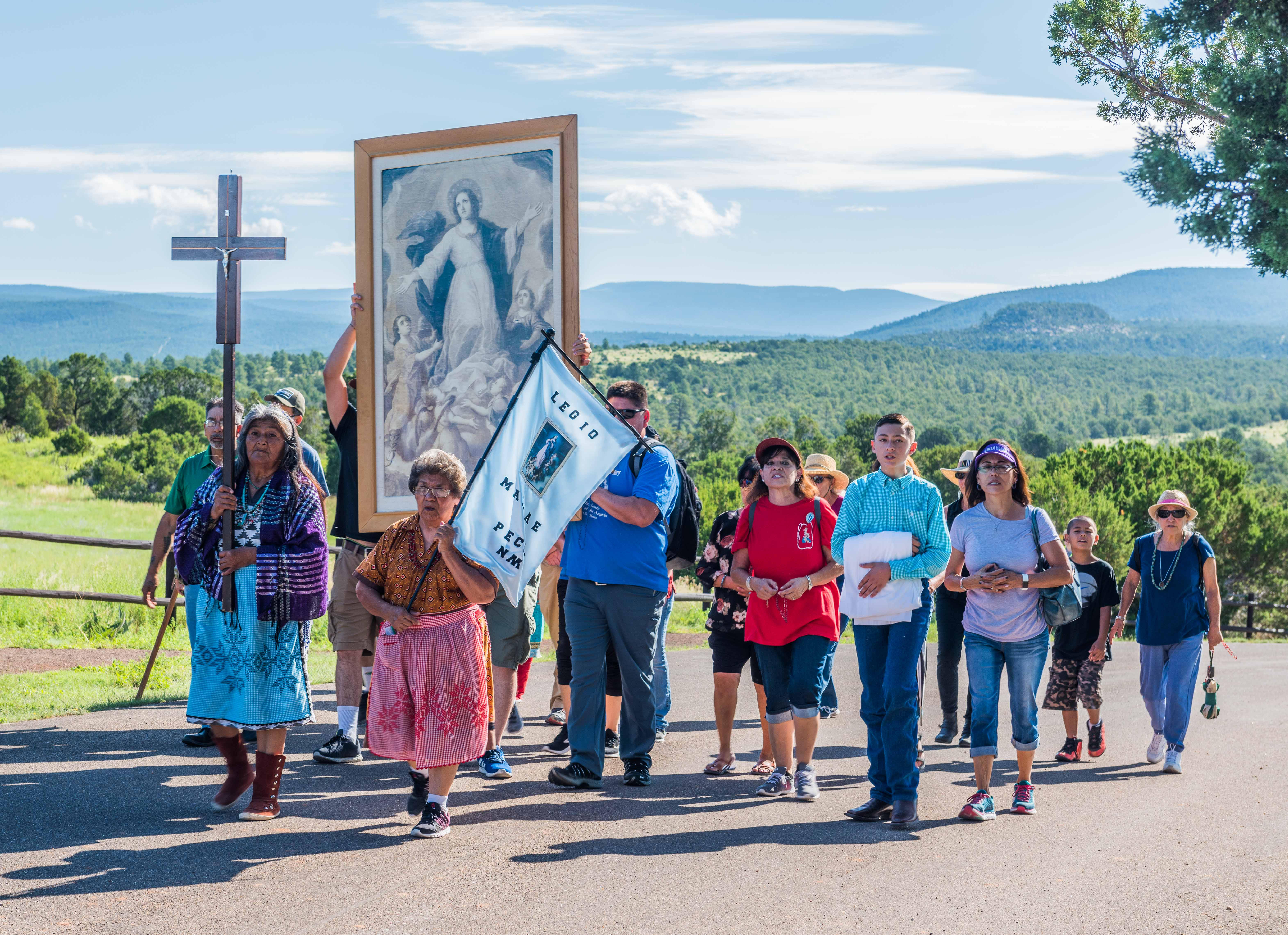 People walking along a roadway in a procession.