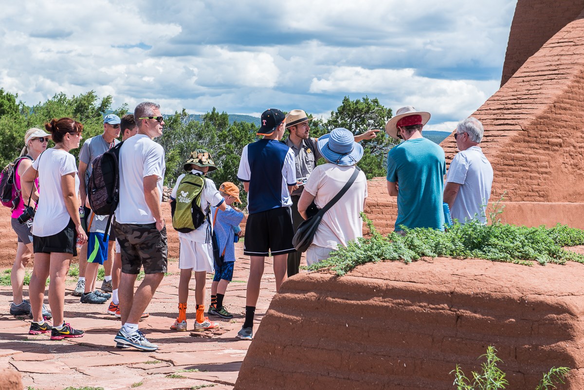 Ranger leading a group of visitors in front of historic mission church