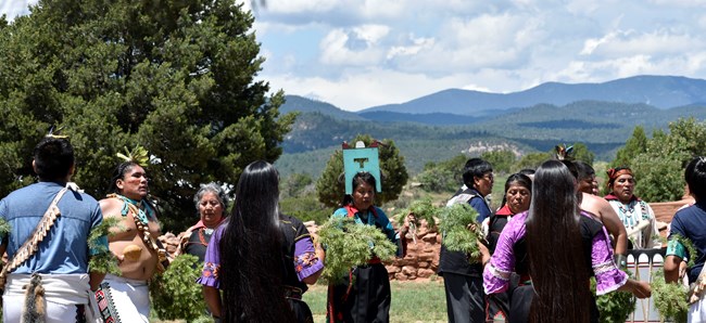 Native Americans performing a dance for a crowd of visitors for a special celebration.