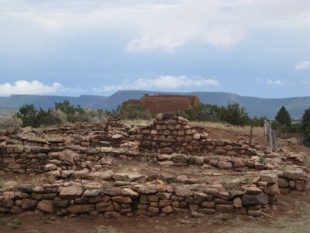 Foundation of pueblo looking toward church and hills in distance