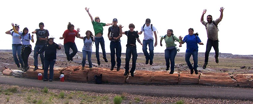 YCC crew members leap off petrified log