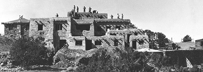 men seen standing on roof of construction site