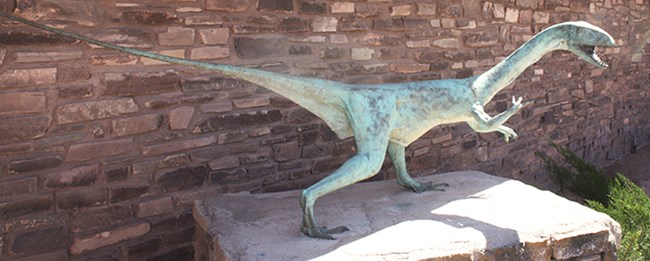 dinosaur statue on stone pedestal dinosaur statue on stone pedestal