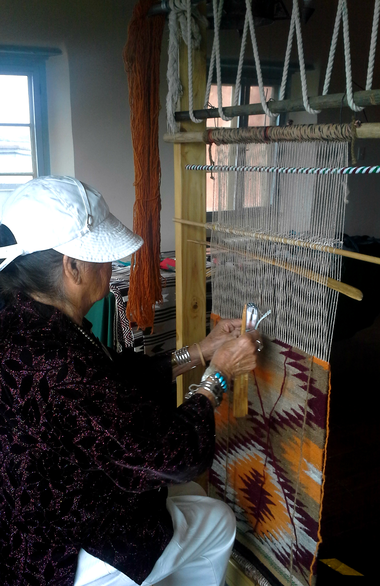 Lucille Smith weaving a rug on a tradition Diné loom Lucille Smith weaving a rug on a tradition Diné loom