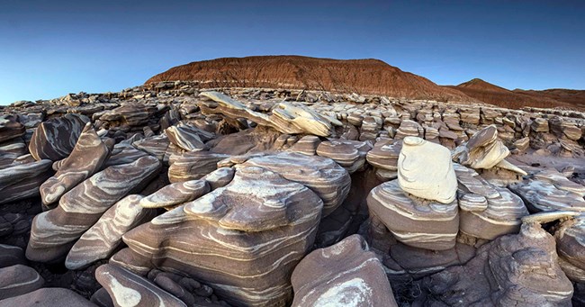 Field of eroded rocks with brown and cream swirls.