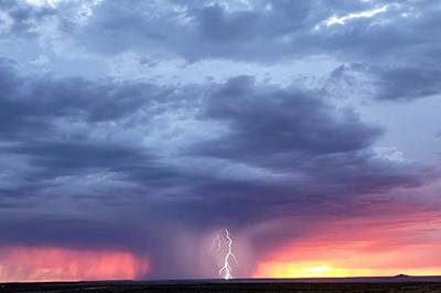 Thunderstorm with lightning at sunset.