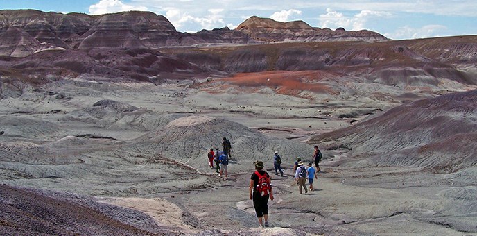 hikers in colorful badland basin