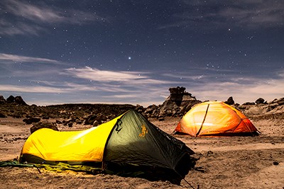 Tents glow under the night sky in the wilderness area