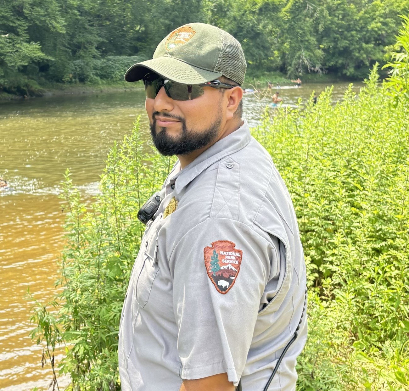 Cardoza_in_Uniform A man stands in front of a body of water wearing an NPS uniform and black sunglasses