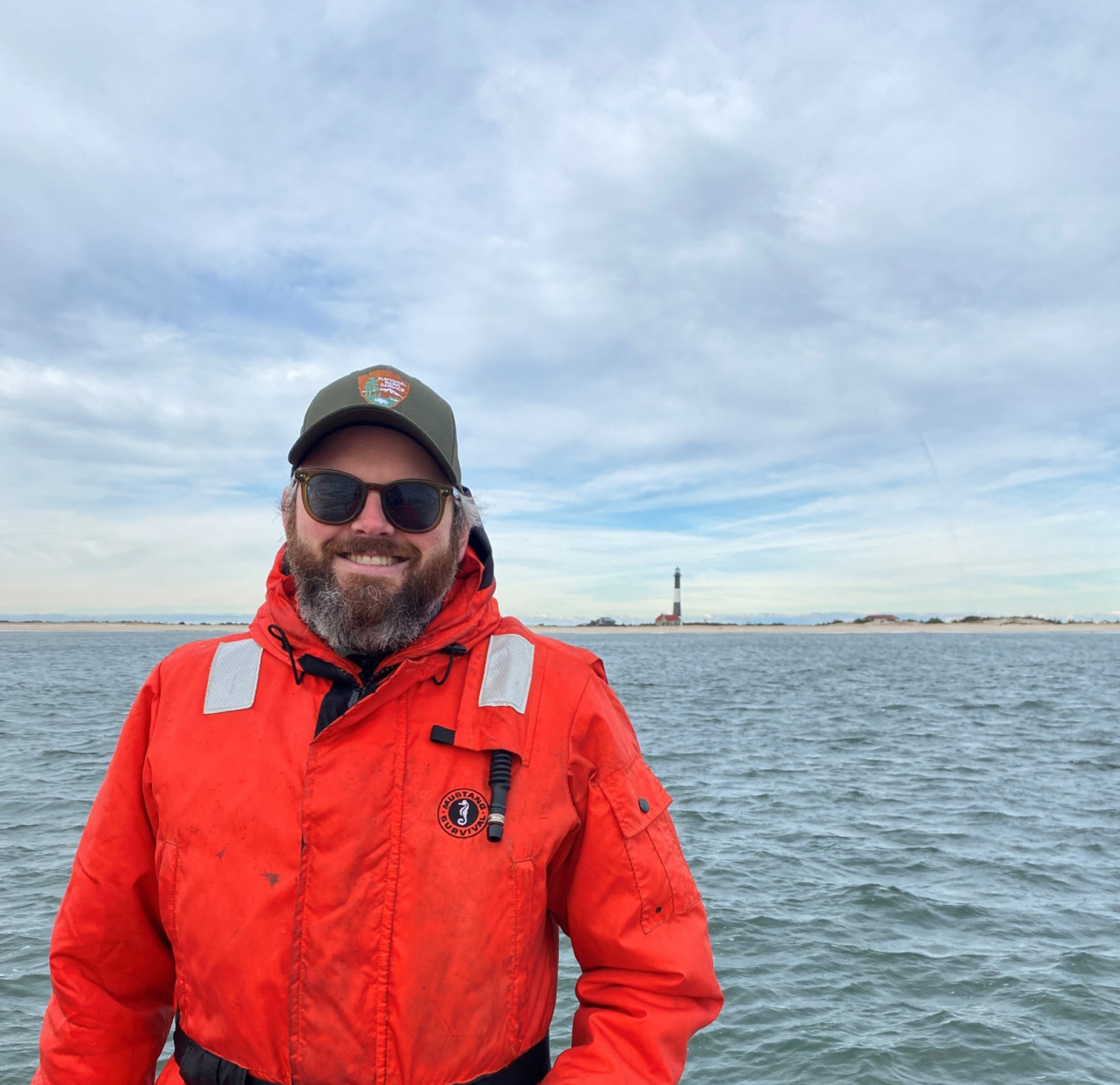 Chief of Resources Brendan Newell on a boat with the lighthouse in the background