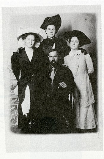 A fading black and white photo of (from left to right) Muriel, Hortense, and Frances Lawton with Bill Keys in the middle.