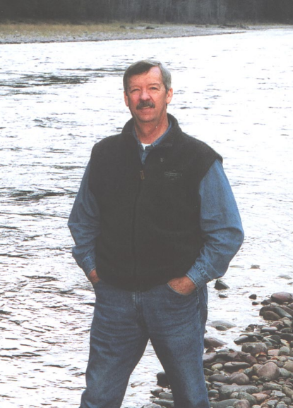 A man stands in front of a river