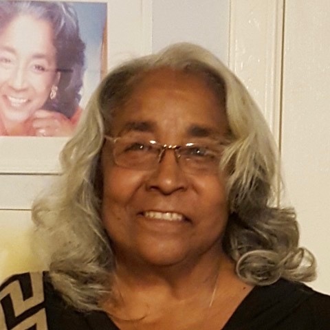 Headshot of black woman with shoulder length grey hair and glasses