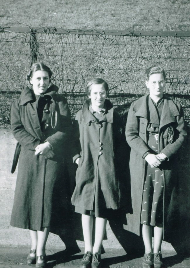 A black and white photograph of Irene (left), Bucky (middle) and Hobbie (right) Buckner standing together and posing for the camera.