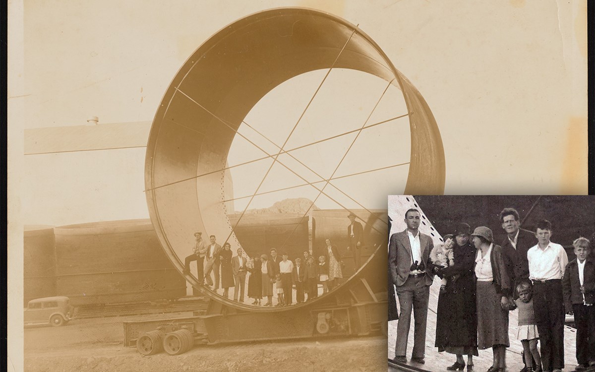 A black and white photo of the Godbey family standing inside of a thirty-foot-wide penstock pipe.