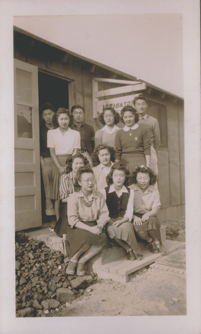 An old photo of 11 Minidoka Irrigator staffers posing for a picture on the front steps of the Irrigator Building.