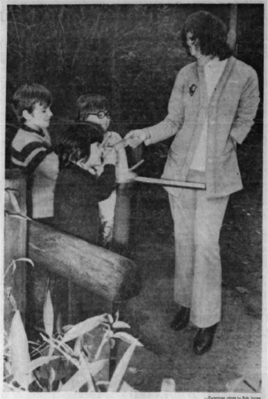 Black and white photo of Ranger Marilyn speaking with three children.