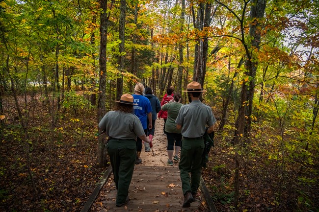 A group of rangers and park visitors hiking on a trail
