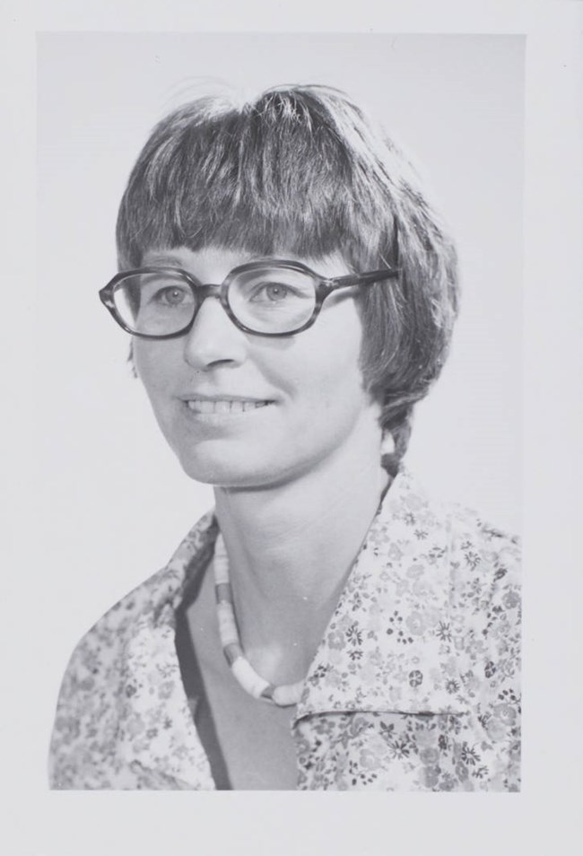 A black and white portrait of Margaret Lyneis smiling for the camera.