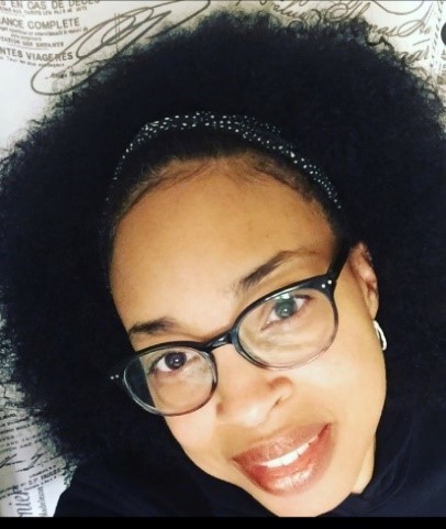 Woman with glasses, dark eyes and hair smiles