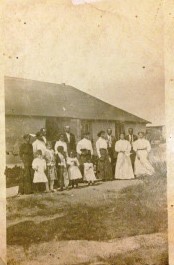 Walker family and neighbors, other homesteaders, after a prayer meeting held at the Walkers place. All standing in front of the Walkers home