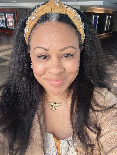 Portrait photo of woman with long black hair and a yellow hair band.