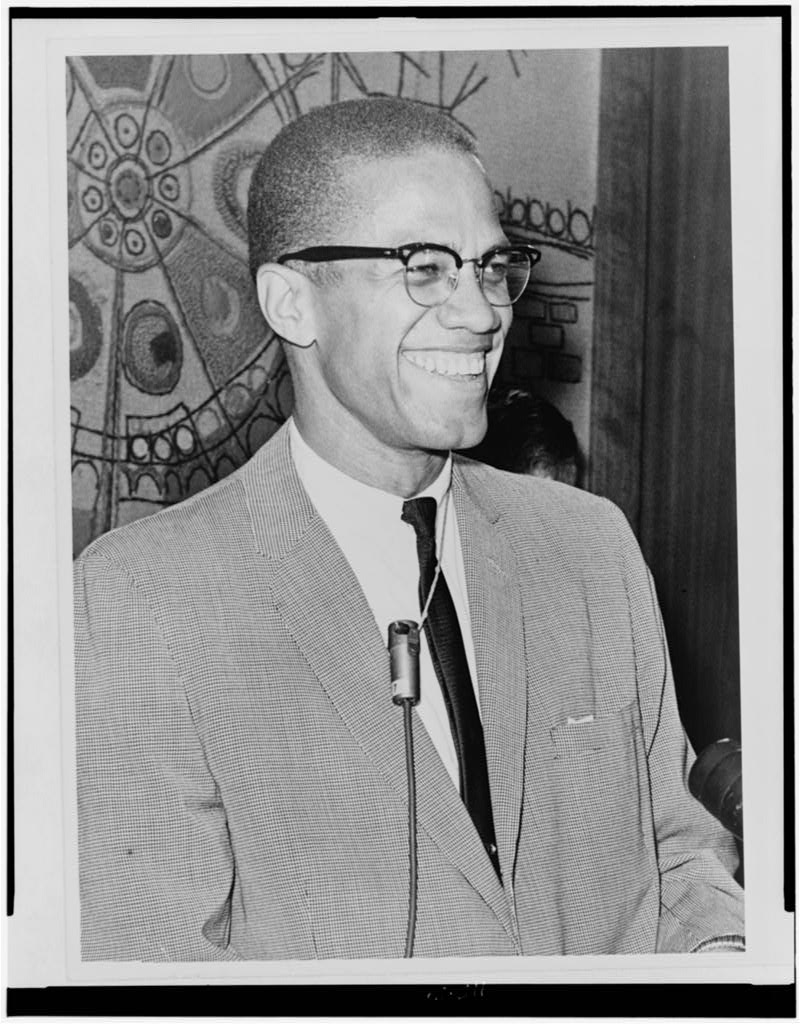 Half-length portrait of Black man wearing glasses, facing right