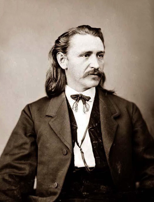 This is a headshot or portrait image of Elias C. Bondinot from 1860. The photo is in black and white and shows a man with shoulder-length dark hair, a mustache wearing a dark suit vest white shirt and a bowtie.