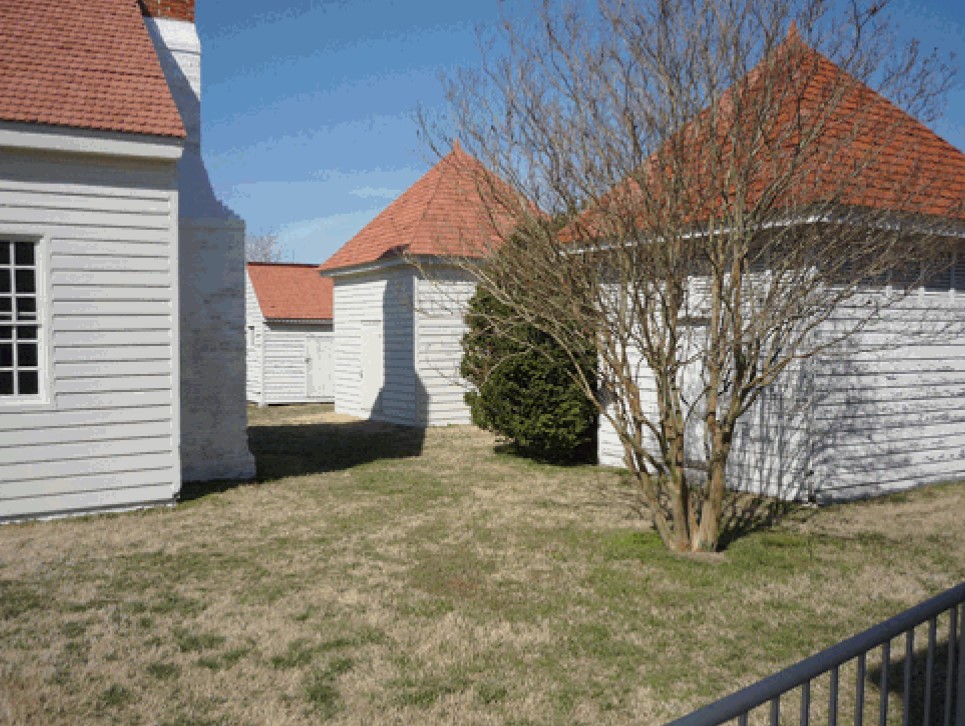 Appomattox Plantation Outbuildings Four buildings with white siding and red shingled roofs.