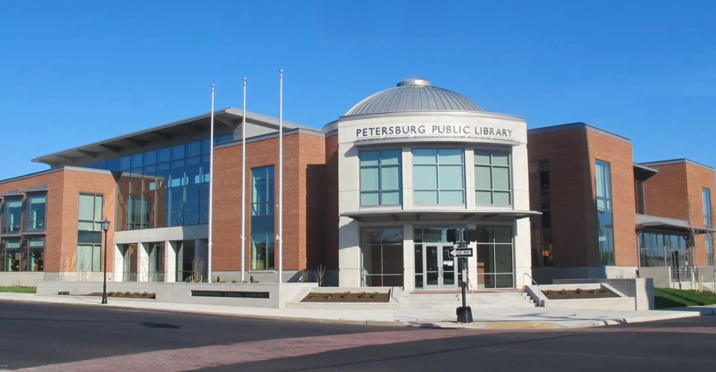 Petersburg Public Library Modern red brick building with large windows and text reading Petersburg Public Library.