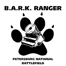 Black dog pawprint with the outline of a mortar cannon inside the pawprint. Text above pawprint reads BARK Ranger and text below pawprint reads Petersburg National Battlefield. Logo has a white background.