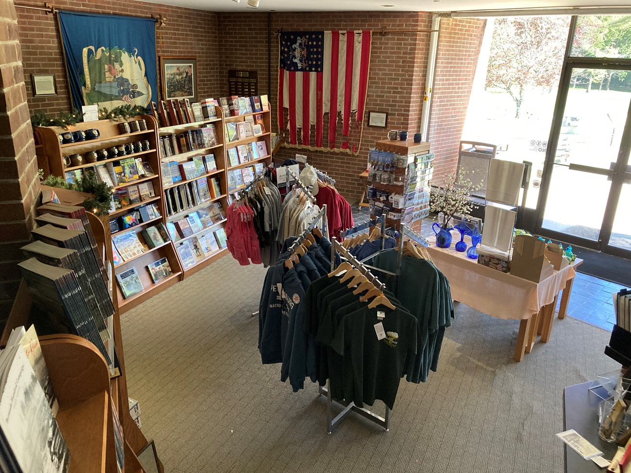 Looking down on a bookstore with books, mugs, and t-shirts on display.