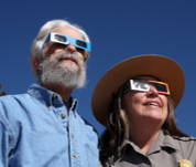Two staff members wearing solar glasses to safely view an eclipse.