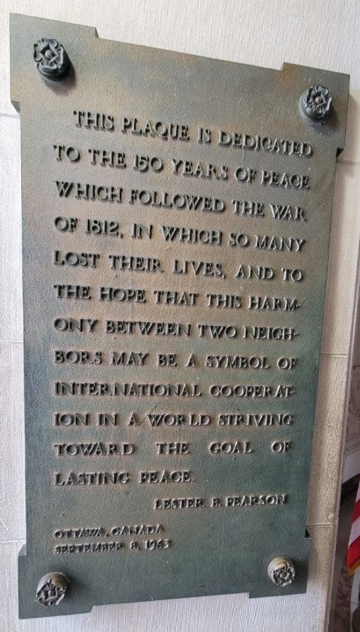 Bronze tablet hung on wall dedicated to 150 years of peace between the United States and Canada