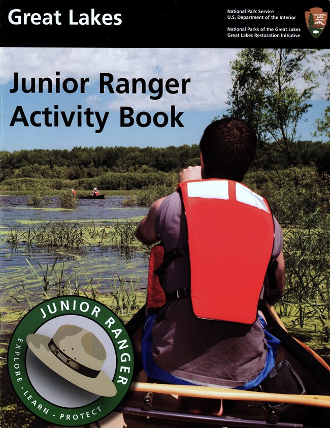Book cover showing the back of a man paddling a canoe through marshland. The Junior Ranger Logo is in the bottom left corner.