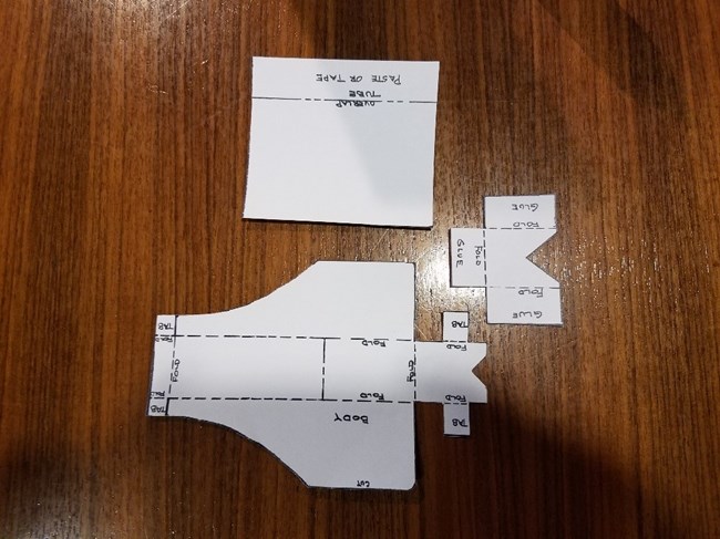 Image of 3 different shapes cut out of paper laying flat on a table.