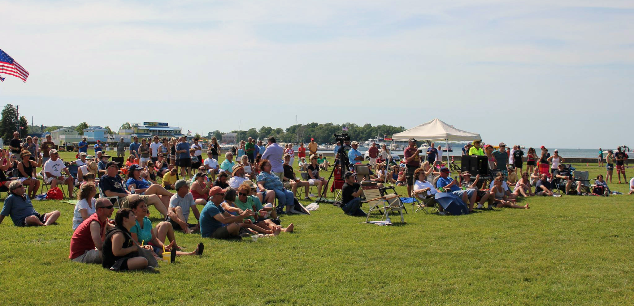 Crowd of the 2017 Music Festival, people standing and sitting listening to music on the lawn.