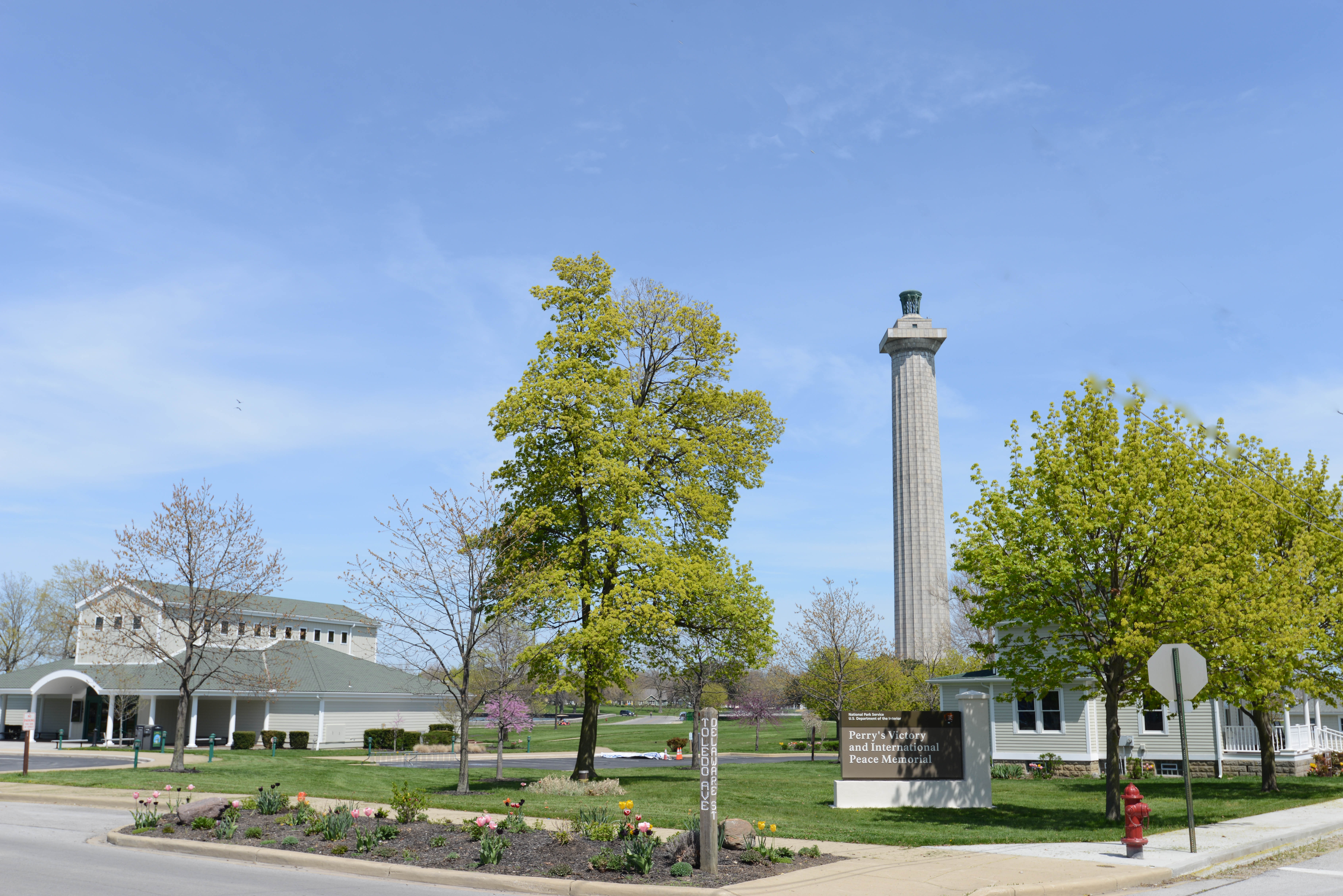 Memorial column in background, Visitor Center to the side, and park sign in foreground