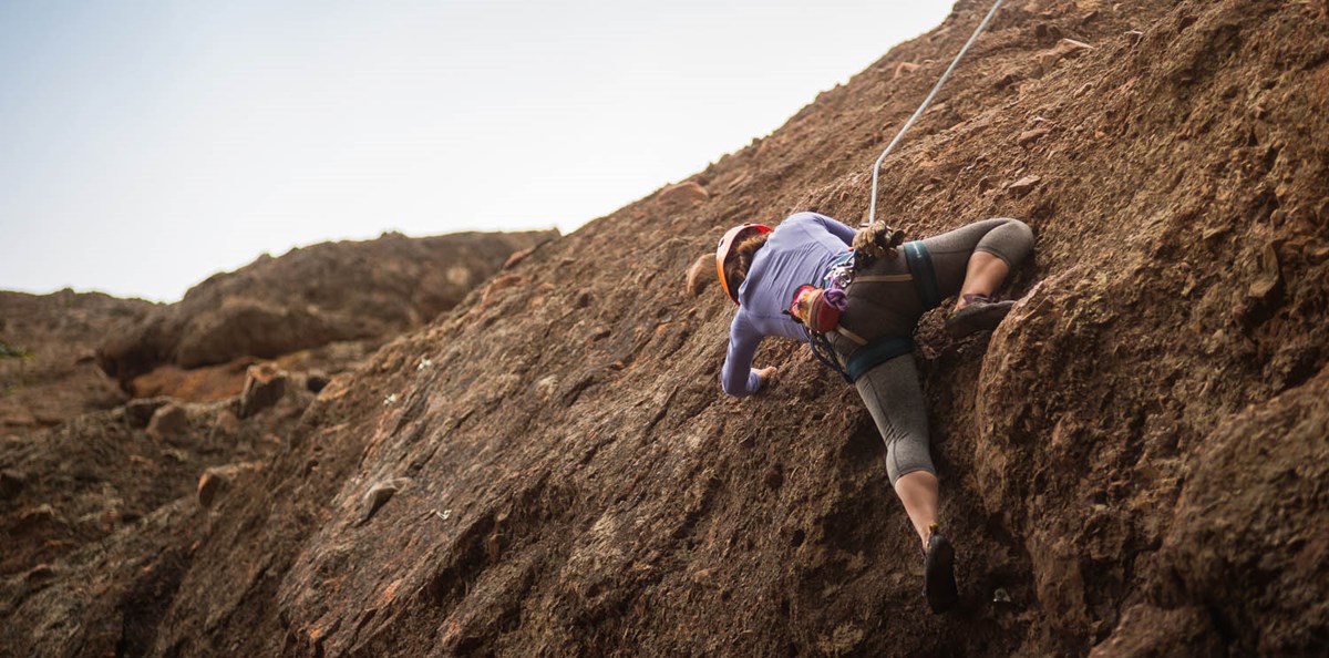 A climber ascends a rock wall.