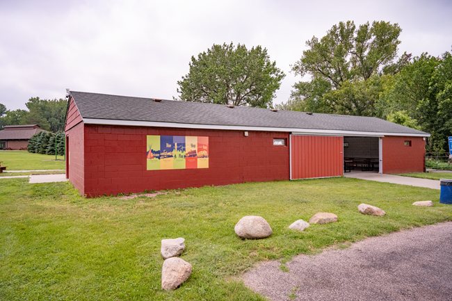 A large red building next to a parking area.