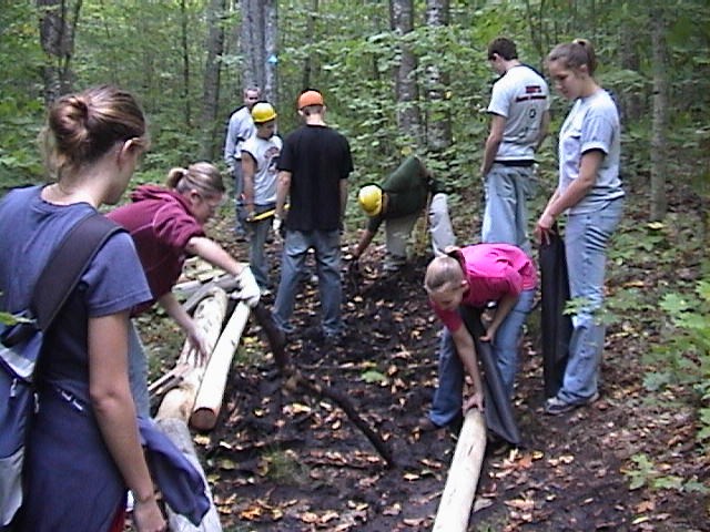 Laying wood and preparing surface for trail creation.