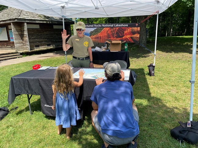 a volunteer swears in a young junior ranger at an event