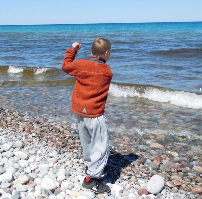 Boy skipping stones on Lake Superior