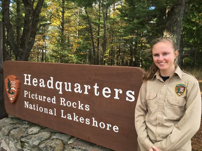 Pictured Rocks Intern standing next to the park sign