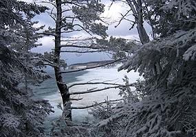 This far-away photo of Miners Beach was taken from the trail to Miners Castle, through snow-covered trees. This far-away photo of Miners Beach was taken from the trail to Miners Castle, through snow-covered trees.