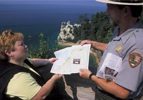 While perusing the park newspaper, a Ranger assists a visitor to Pictured Rocks National Lakeshore.