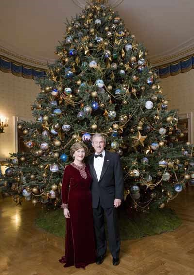 Celebrating the 2007 holiday season, President George W. Bush and Mrs. Laura Bush pose in front of the Christmas Tree in the Blue Room of the White House
